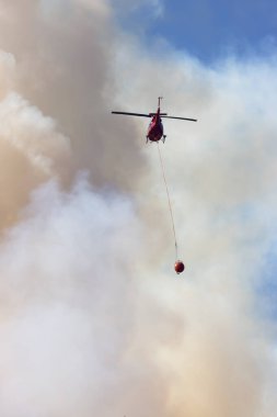 Sıcak bir yaz günü, Hope yakınlarındaki dağda, BC Orman Yangını ve Dumanı 'nın üzerinde uçan Wildfire Servis Helikopteri. British Columbia, Kanada. Doğal Felaket