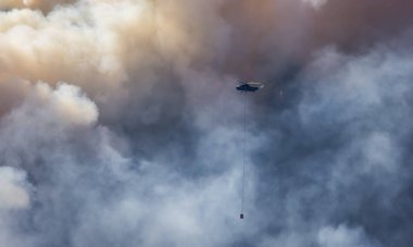 Sıcak bir yaz günü, Hope yakınlarındaki dağda, BC Orman Yangını ve Dumanı 'nın üzerinde uçan Wildfire Servis Helikopteri. British Columbia, Kanada. Doğal Felaket