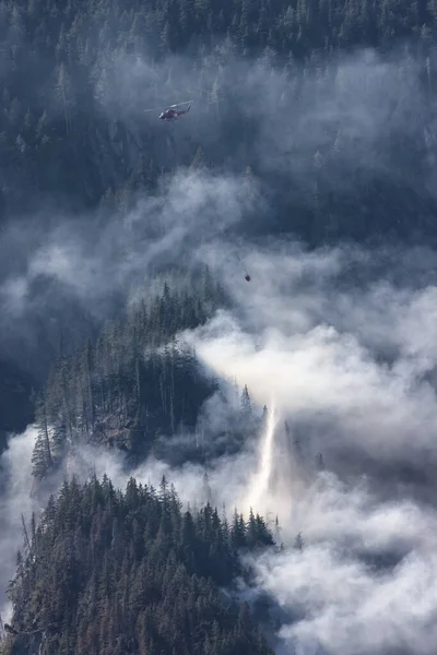 在炎热阳光明媚的夏日 野火服务直升机在霍普附近的山上飞越不列颠哥伦比亚省森林大火和烟雾 不列颠哥伦比亚省 加拿大 自然灾害 — 图库照片