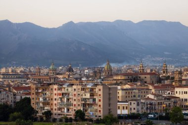 Palermo, Sicilya, İtalya 'da geçmişi dağlarla çevrili yerleşim evleri ve tarihi kilise binaları. Gündoğumu Gökyüzü.