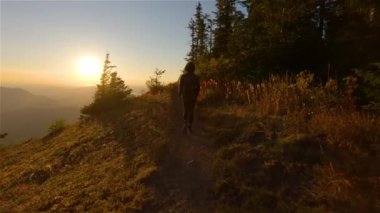 Güneşli günbatımında Sonbahar Renkleri ile Kanada Manzarasında Maceracı Kadın Yürüyüşü. Elk Dağı, Chilliwack, Vancouver 'ın doğusu, British Columbia, Kanada. Macera Yolculuğu Konsepti. Yavaş Hareket