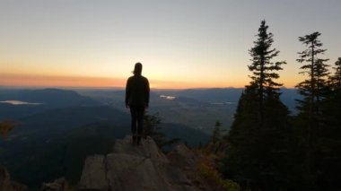 Güneşli günbatımında Sonbahar Renkleri ile Kanada Manzarasında Maceracı Kadın Yürüyüşü. Elk Dağı, Chilliwack, Vancouver 'ın doğusu, British Columbia, Kanada. Macera Yolculuğu Konsepti. Yavaş Hareket