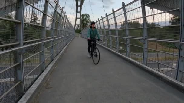 骑自行车的妇女骑在横跨加拿大公路的行人天桥上在现代城市郊区 夕阳西下萨里 温哥华 不列颠哥伦比亚省 加拿大慢动作 — 图库视频影像