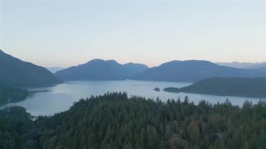 Dağ manzarasının etrafındaki ormandaki göl ve yeşil ağaçların havadan görünüşü. Kanada doğası. Pacific Northwest, British Columbia, Kanada 'da çekildi..