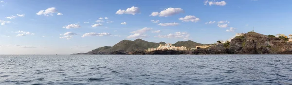 stock image Homes in a touristic Spanish Town by the Mediterranean Sea. Cloudy Sky. Cape Palos, Spain. Panorama