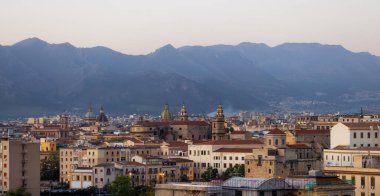 Palermo, Sicilya, İtalya 'da arkası dağlarla çevrili konutlar ve tarihi binalar. Gündoğumu Gökyüzü.