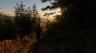 Güneşli günbatımında Sonbahar Renkleri ile Kanada Manzarasında Maceracı Kadın Yürüyüşü. Elk Dağı, Chilliwack, Vancouver 'ın doğusu, British Columbia, Kanada. Macera Yolculuğu Konsepti. Yavaş Hareket