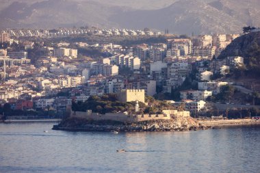 Ege Denizi kıyısındaki bir turistik kasabadaki evler ve binalar. Kusadasi, Türkiye. Güneşli bir akşam..