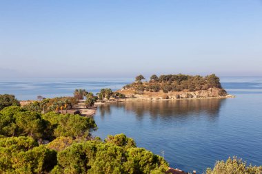 Ege Denizi kıyısındaki bir turistik kasabada ağaçlar ve plajlar. Kusadasi, Türkiye. Güneşli Sabah Gündoğumu.