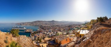 Ege Denizi kıyısındaki bir turistik kasabadaki evler ve binalar. Kusadasi, Türkiye. Güneşli Sabah Gündoğumu. Tepenin tepesinde. Panorama