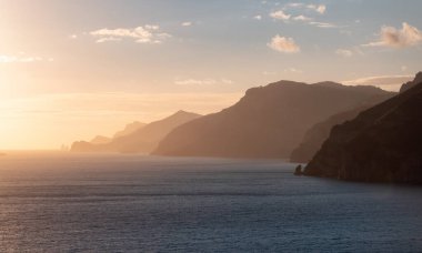 Tyrhenian Denizi kıyısındaki Rocky Cliffs ve Mountain Peyzajı. Amalfi Sahili, İtalya. Doğa Arkaplanı. Günbatımı Gökyüzü