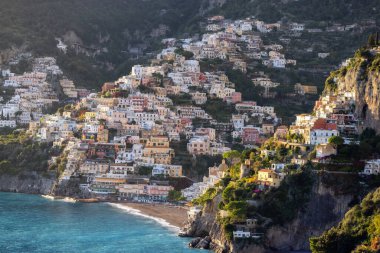 Turistik Şehir, Positano, Rocky Cliffs ve Tyrhenian Denizi kıyısındaki Dağ Manzarası. Amalfi Sahili, İtalya. Güneşli Günbatımı