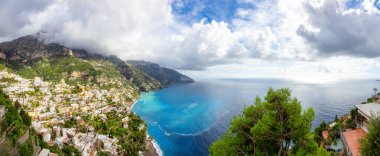Turistik Şehir, Positano, Rocky Cliffs ve Tyrhenian Denizi kıyısındaki Dağ Manzarası. Amalfi Sahili, İtalya. Bulutlu Gökyüzü. Panorama