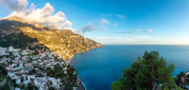Turistik Şehir, Positano, Rocky Cliffs ve Tyrhenian Denizi kıyısındaki Dağ Manzarası. Amalfi Sahili, İtalya. Günbatımı Gökyüzü Panoraması