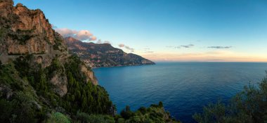 Turistik Şehir, Positano, Rocky Cliffs ve Tyrhenian Denizi kıyısındaki Dağ Manzarası. Amalfi Sahili, İtalya. Günbatımı Gökyüzü Panoraması