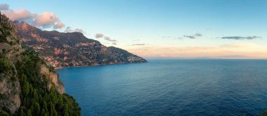 Turistik Şehir, Positano, Rocky Cliffs ve Tyrhenian Denizi kıyısındaki Dağ Manzarası. Amalfi Sahili, İtalya. Günbatımı Gökyüzü Panoraması