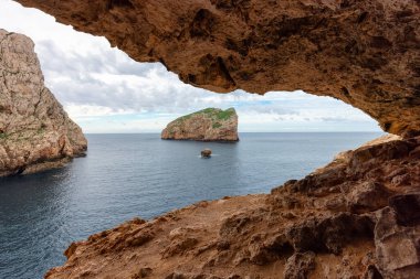 Akdeniz 'deki Kayalıkları olan Rocky Coast' taki mağarada. Bulutlu Gökyüzü. Porto Conte Bölgesel Doğal Parkı, Sardinya, İtalya. Doğa Arkaplanı.