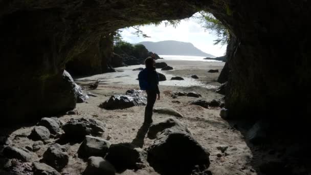 女性太平洋の海岸を望むビーチの洞窟を歩く 晴れ空 サンヨゼフ湾 ケープスコット州立公園 北バンクーバー島 カナダ カナダの自然背景 シネマティック4K — ストック動画
