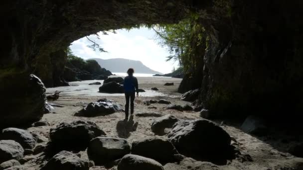 Kobieta Spacerująca Jaskini Plaży Widokiem Wybrzeże Oceanu Spokojnego Słoneczne Niebo — Wideo stockowe