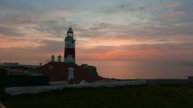 Europa Point Deniz Feneri 'nin arka planında deniz var. Renkli Bulutlu Gün Doğumu Gökyüzü. Cebelitarık, Birleşik Krallık. 4k Sinematik