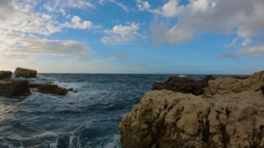 Rocky coast with waves on Mediterranean Sea. Italy, Europe. Nature Background. Sunset Sky. Slow Motion Cinematic
