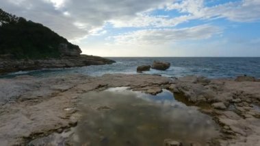 Rocky coast with waves on Mediterranean Sea. Italy, Europe. Nature Background. Sunset Sky. Slow Motion Cinematic