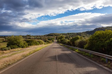 Scenic Road near a town by the Sea. Costa Rei, Sardinia, Italy. Sunny Cloudy Day.