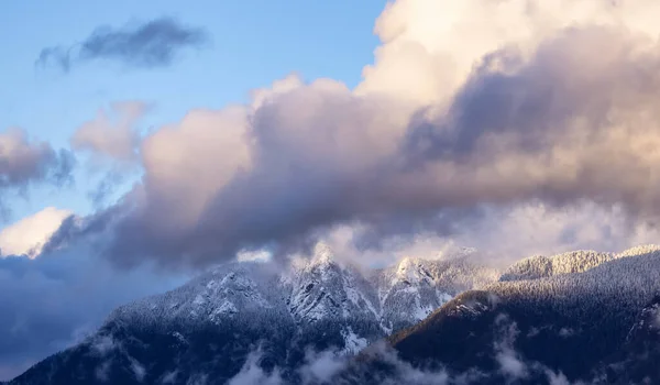 North Shore Mountains Covered in Snow and Clouds. North Vancouver, British Columbia, Canada. Nature Background. Sunset