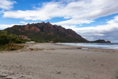 Deniz kıyısındaki bir kasabada kumsal. Foxi Manna, Sardinya, İtalya. Dağ Arkaplanı