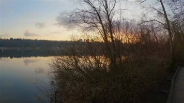 Modern şehirde Peaceful Lake, Deer Lake Park. Burnaby, Vancouver, BC, Kanada. Renkli Kış Günbatımı Gökyüzü. Slow Motion Sinematik Pan