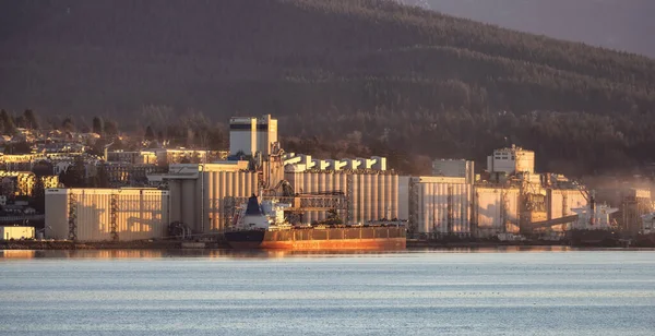 Industrial Sites in Vancouver Harbour with Mountains in Background. Vancouver, British Columbia, Canada. Sunrise