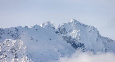 Tantalus Range covered in Snow and Clouds during Winter Season. Near Whistler and Squamish, British Columbia, Canada. Nature Background