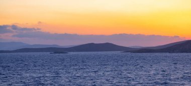Rocky Island on Mediterranean Sea. Rinia near Mikonos, Greece, Europe. Nature Background. Sunrise Sky