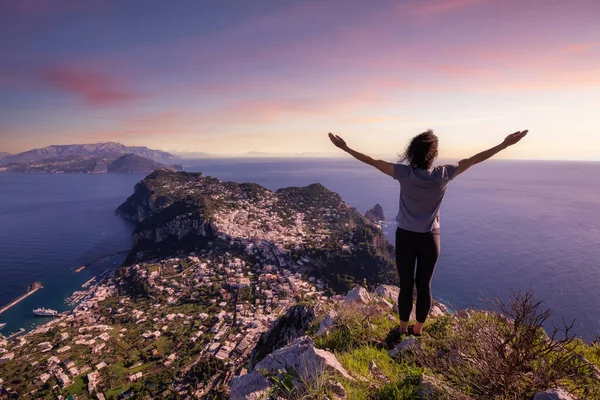 Adventure Woman Hiking on mountain at Touristic Town, Capri Island, in Bay of Naples, Italy. Twilight Sunrise Sky Art Render.
