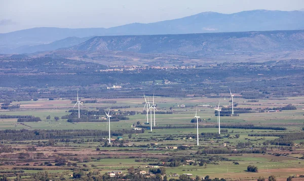 Wind Turbines and Famrs near Small Town in the Countryside, Guspini, Sardinia, Italy. Sunny Fall Season Day.