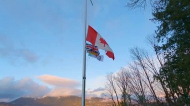 Canadian National Flag in the Wind. Blue Sunset Sky. Stanley Park, Downtown Vancouver, British Columbia, Canada. Slow Motion Cinematic