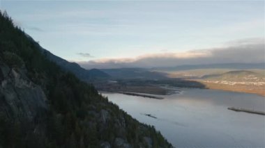 Ocean Inlet with Rocky Mountains in Canadian Landscape. Aerial Nature Background. Howe Sound, Squamish, BC, Canada. Sunset. Cinematic