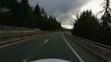 Driving on Sea to Sky Highway between Squamish and Vancouver, BC, Canada. Cloudy Winter Sunset Sky. Slow Motion