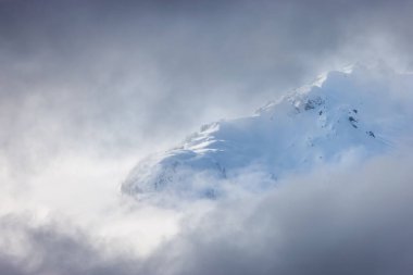 Tantalus Range covered in Snow and Clouds during Winter Season. Near Whistler and Squamish, British Columbia, Canada. Nature Background