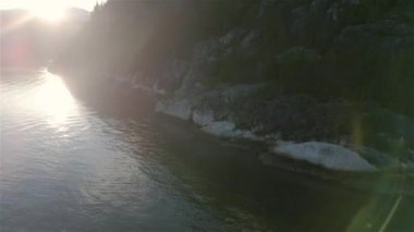 Ocean Inlet with Rocky Mountains in Canadian Landscape. Aerial Nature Background. Howe Sound, Squamish, BC, Canada. Sunset. Cinematic