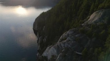 Ocean Inlet with Rocky Mountains in Canadian Landscape. Aerial Nature Background. Howe Sound, Squamish, BC, Canada. Sunset. Cinematic