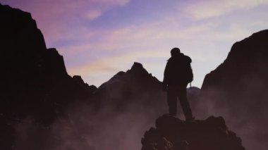 Rocky Dağı 'nın tepesindeki Maceracı Adam. Doğa Arkaplanı. Sunset 'te Bulutlu Gökyüzü. 3d Hazırlama.