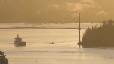 Lions Gate Bridge with Ship leaving the port. Downtown Vancouver, British Columbia, Canada. Winter Sunrise.