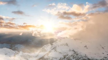 Snow and Cloud covered Canadian Mountain Landscape Nature Background. Dramatic Sunset Sky Art Render. Cinemagraph Continuous Loop Animation. Near Vancouver, British Columbia, Canada. Aerial