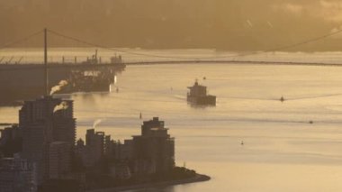 Lions Gate Bridge with Ship leaving the port. Downtown Vancouver, British Columbia, Canada. Winter Sunrise. Slow Motion Cinematic