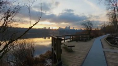 Trail by Peaceful Lake in the modern city, Deer Lake Park. Burnaby, Vancouver, BC, Canada. Colorful Winter Sunset Sky. Slow Motion Cinematic Pan.