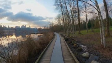 Trail by Peaceful Lake in the modern city, Deer Lake Park. Burnaby, Vancouver, BC, Canada. Colorful Winter Sunset Sky. Slow Motion Cinematic Pan.