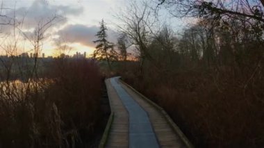 Trail by Peaceful Lake in the modern city, Deer Lake Park. Burnaby, Vancouver, BC, Canada. Colorful Winter Sunset Sky. Slow Motion Cinematic Pan.