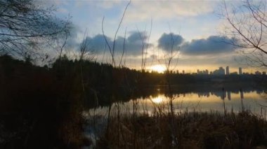 Trail by Peaceful Lake in the modern city, Deer Lake Park. Burnaby, Vancouver, BC, Canada. Colorful Winter Sunset Sky. Slow Motion Cinematic Pan.
