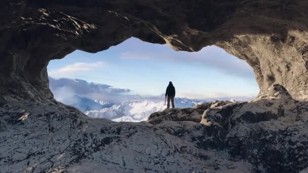 Περιπετειώδης Πεζοπόρος Στέκεται Μια Σπηλιά Πάγου Βραχώδη Βουνά Στο Παρασκήνιο — Αρχείο Βίντεο